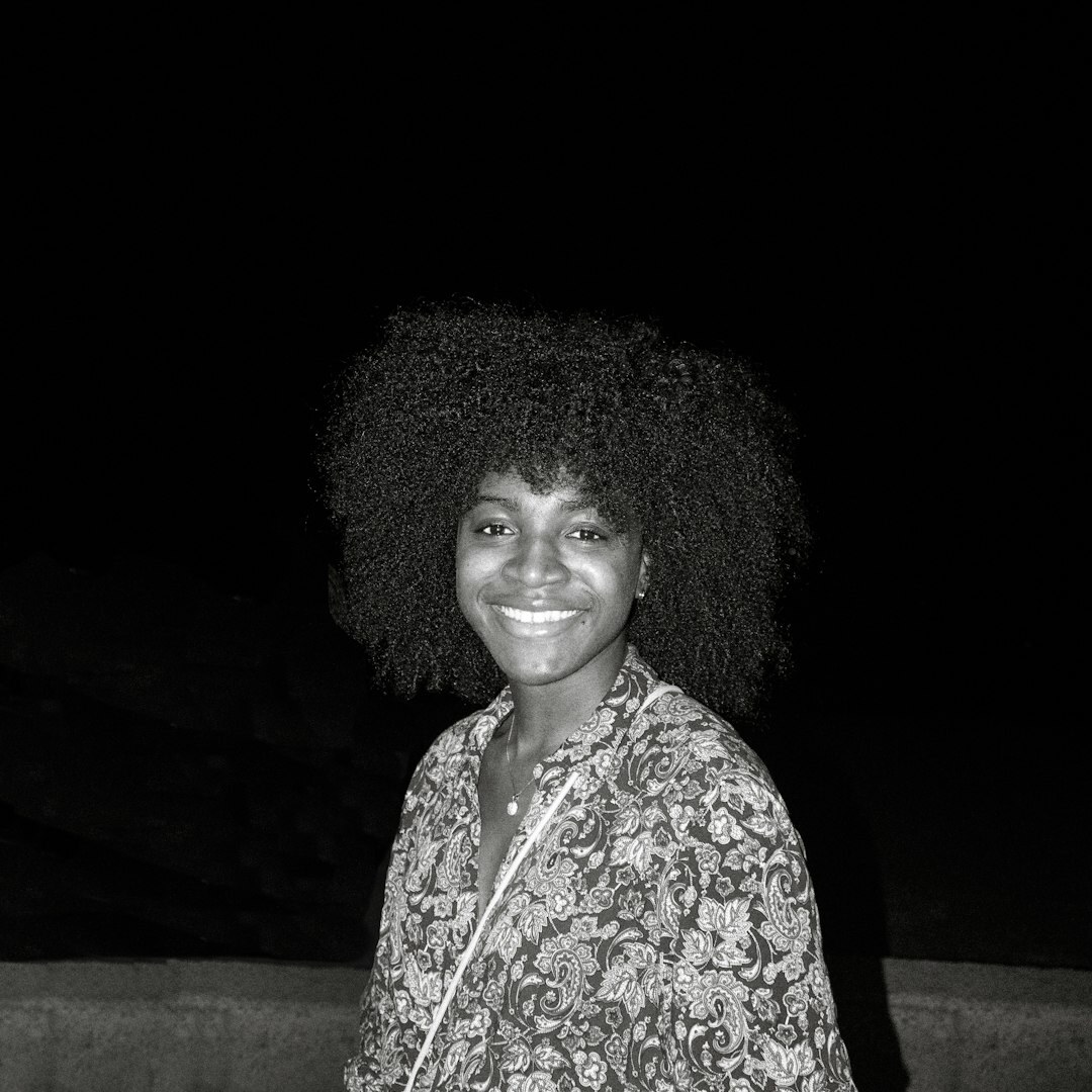 Studio portrait of a Brazilian woman with curly hair smiling